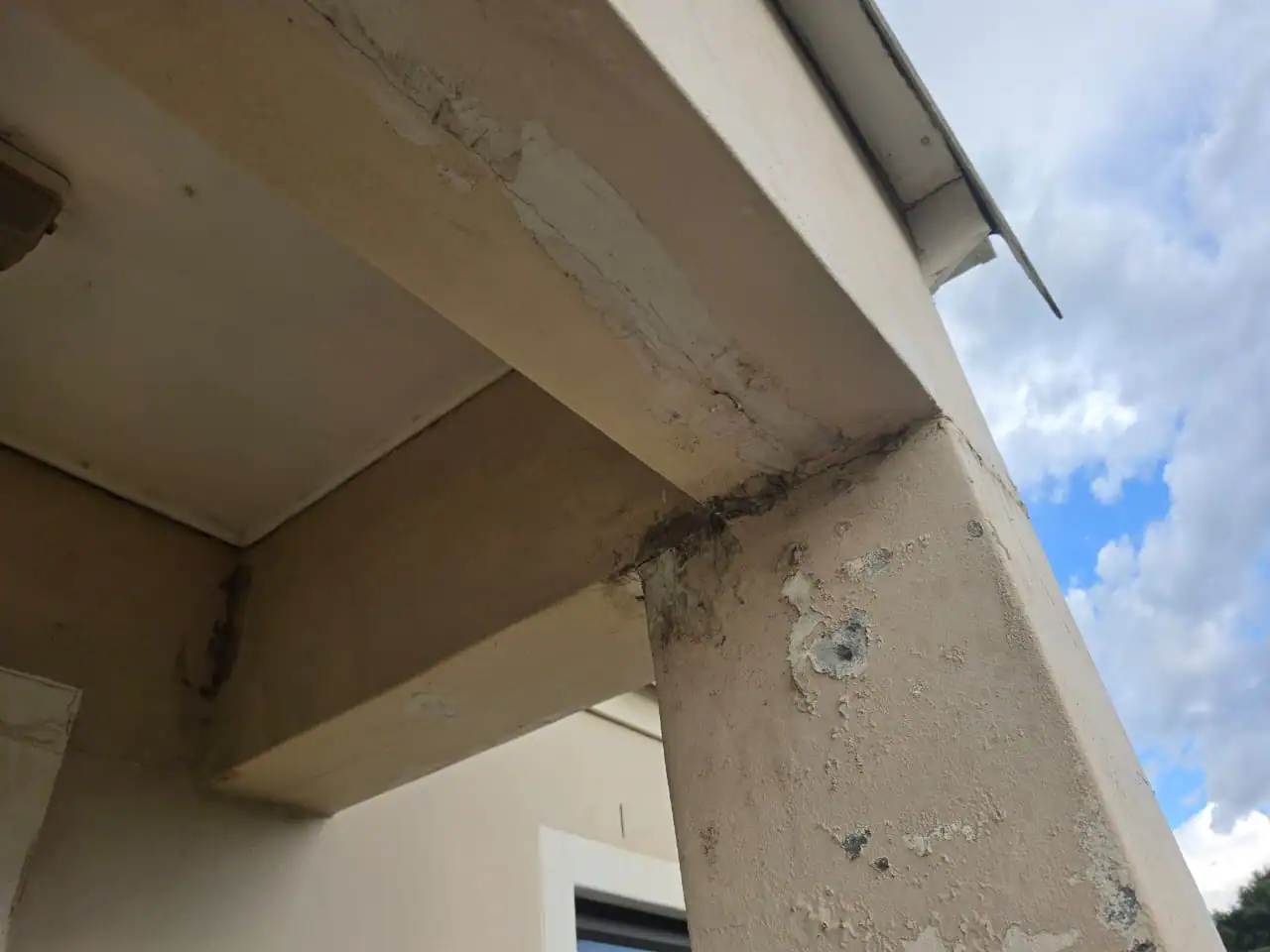 Damp staining and peeling paint on an exterior column and beam before repairs at a private Claremont home