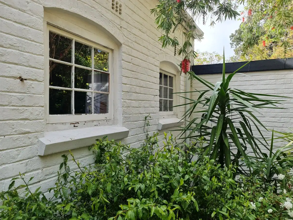 Peeling exterior paint and cracked window putty before repairs at a private Fish Hoek home