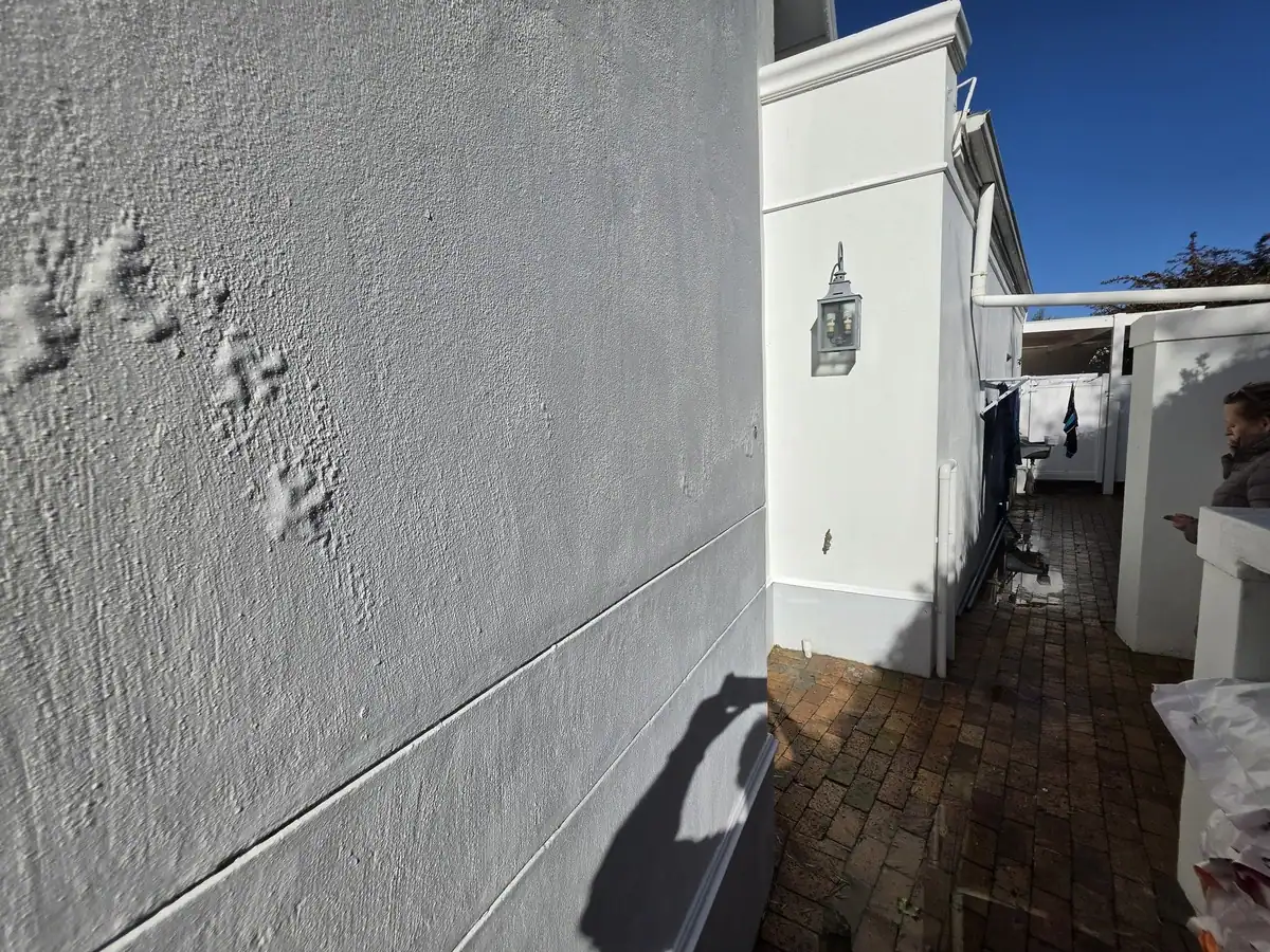 Bubbling and poorly bonded exterior paint before repairs at a Grove Village townhouse in Rondebosch