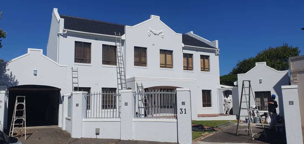 Freshly repainted white exterior walls of a double-storey home in Mellow Wood Estate, Constantia
