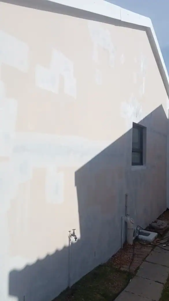 Damp-affected exterior wall being prepared before painting at an older home in Newlands, Cape Town