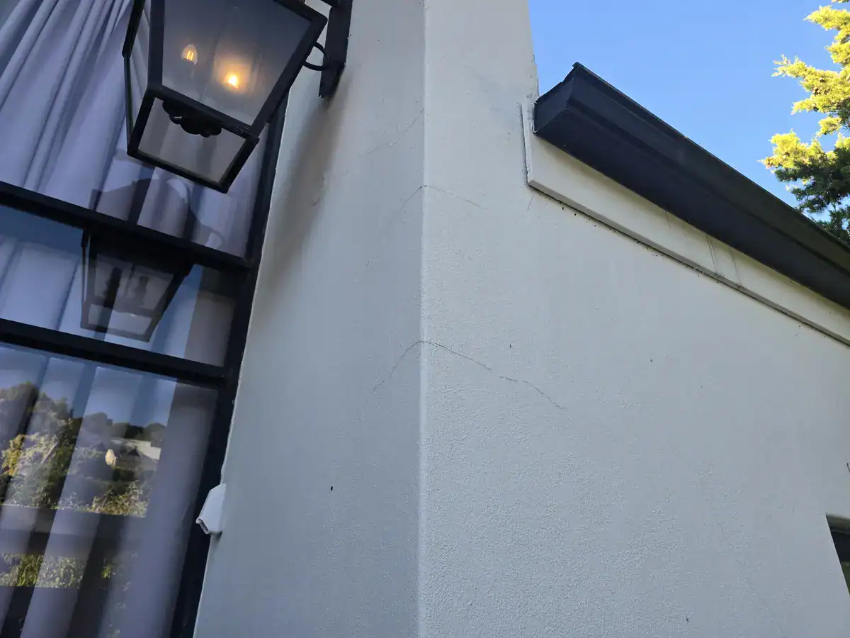 Hairline and wider cracks on an exterior wall before preparation and painting at a Baronetcy Estate home in Plattekloof