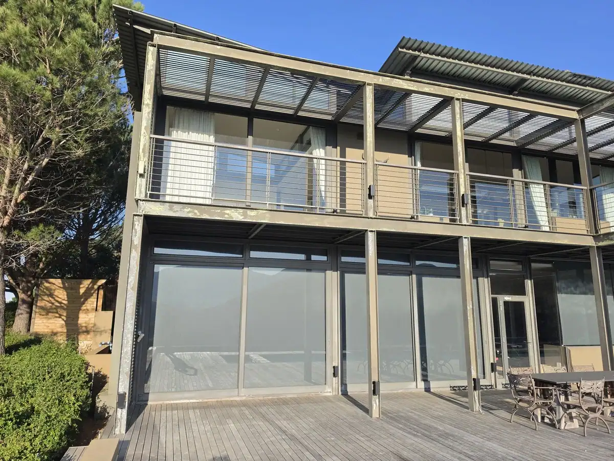 Peeling paint and exposed steel on a pergola before restoration at Rondebosch Oval Estate