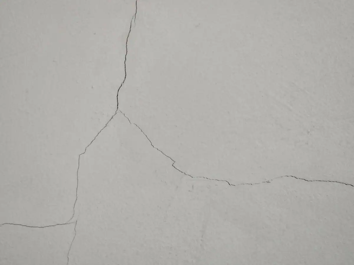 Branching cracks in an exterior plaster wall before repairs and repainting at a private double-storey home in Franschhoek Rural