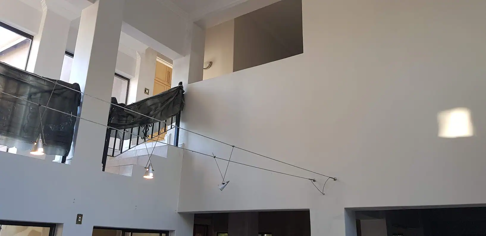 Double-volume interior at a Hemel and Aarde Estate home after wall, ceiling, cornice and painted woodwork preparation and repainting