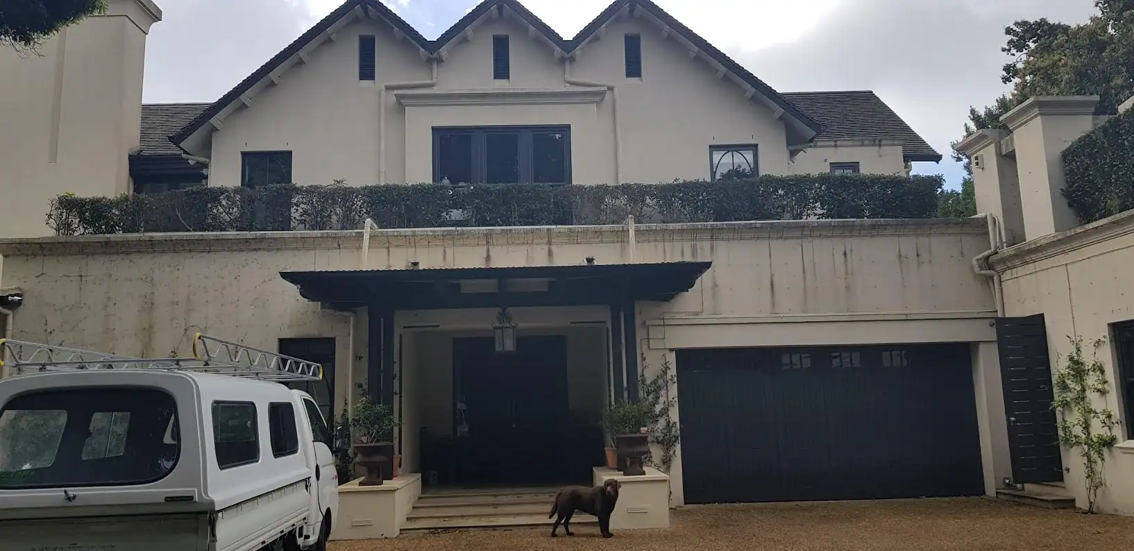 Mould-stained and weathered exterior walls at a double-storey Voëlklip home before damp repairs and repainting