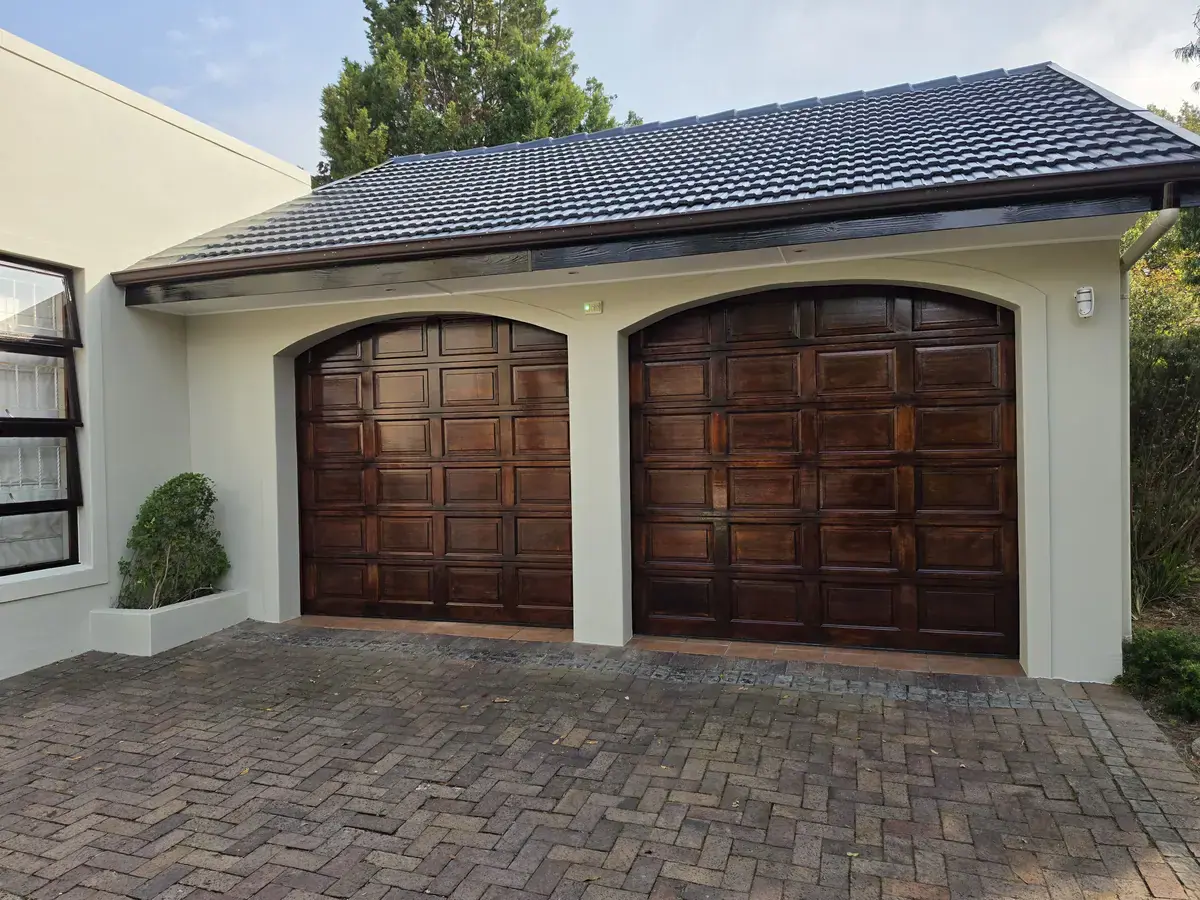 Eversdal home after exterior work, showing refinished timber garage doors, repainted walls and a charcoal tiled roof.
