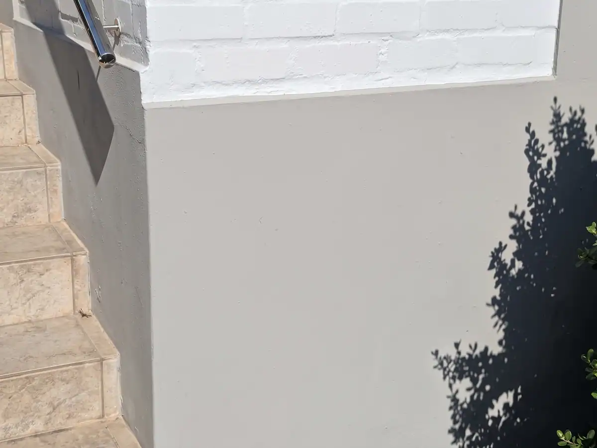 Exterior wall after damp-related preparation and repainting in The Village, Oranjezicht