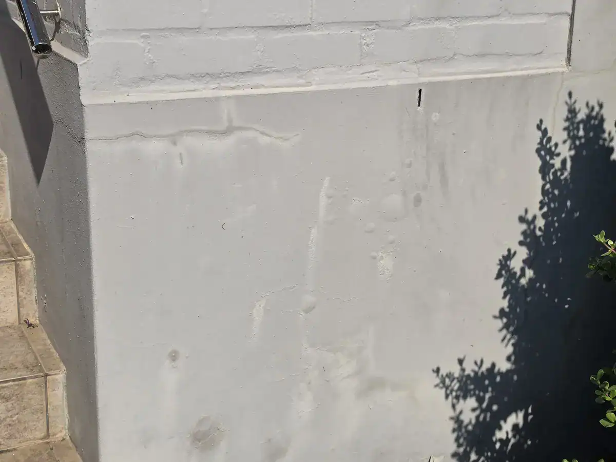 Damp-affected exterior wall with bubbling paint before repairs in The Village, Oranjezicht